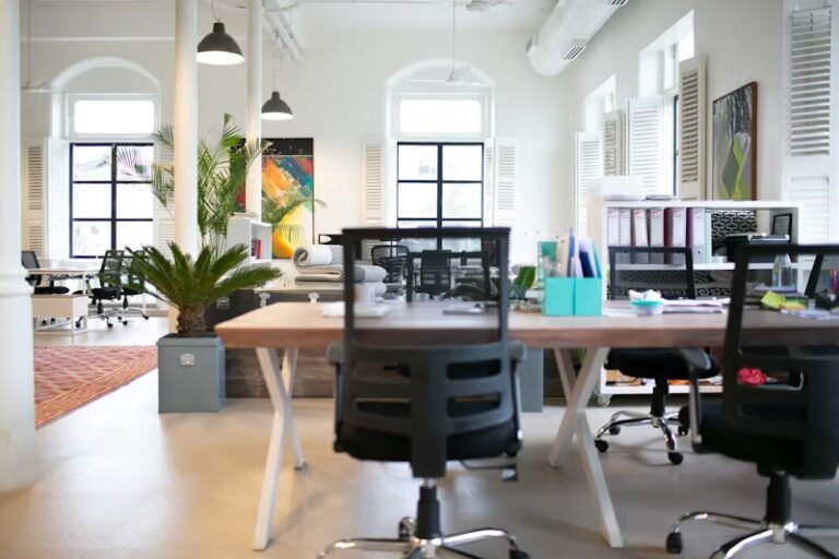 Un espace de co-working coloré et spacieux avec des meubles modernes, des plantes d'intérieur et des œuvres d'art décoratives sublimant l'agencement ouvert.